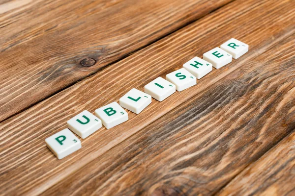 White blocks with publisher lettering and numbers on wooden desk — Stock Photo