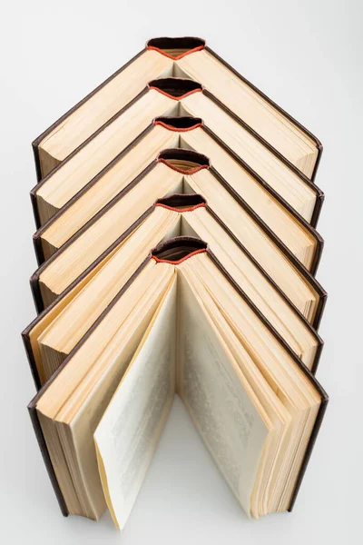 Vista de ángulo alto de libros abiertos sobre fondo gris - foto de stock