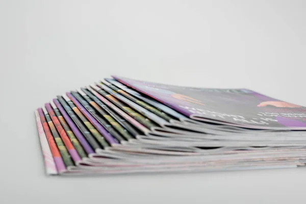 Stack of blurred magazines on grey background — Stock Photo