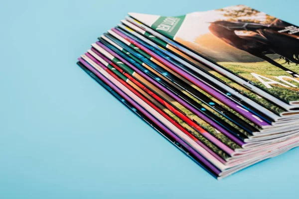 Stack of colorful magazines collection isolated on blue — Stock Photo