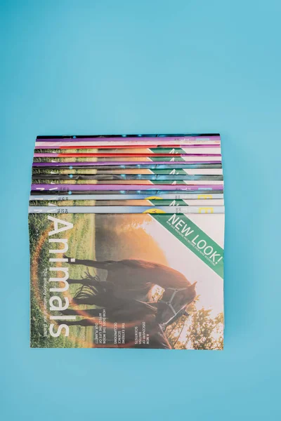 Top view of colorful naturalistic magazines isolated on blue with copy space — Stock Photo