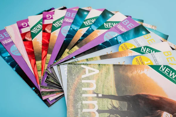 Colección de coloridas revistas naturalistas aisladas en azul - foto de stock