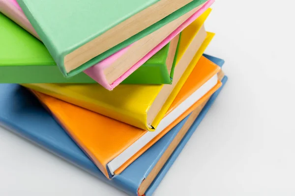 Pila di libri con copertine multicolori su sfondo grigio — Foto stock