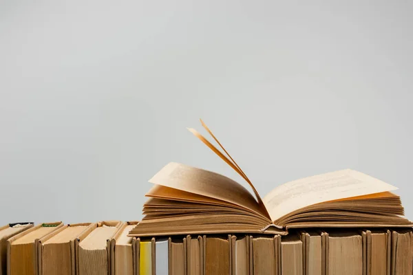 Row of books with open one isolated on grey with copy space — Stock Photo