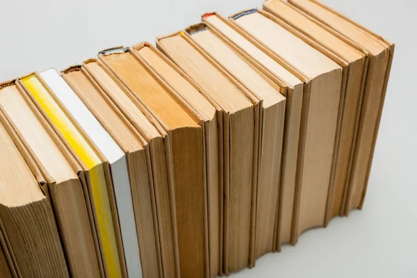 Високий кут огляду рядка книг на сірому фоні — стокове фото