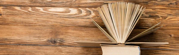 Top view of books on wooden textured desk, banner — Stock Photo