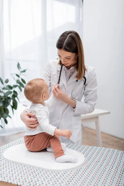 Stetoscopio medico in possesso e toccare il bambino su scala elettronica in ospedale — Foto stock