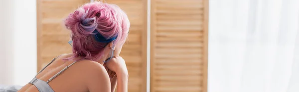 Rückansicht einer jungen Frau mit gefärbten Haaren in der Nähe von Klappbildschirm, Banner — Stockfoto
