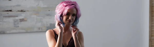 Молода жінка в темній сексуальній білизні посміхається вдома, банер — стокове фото