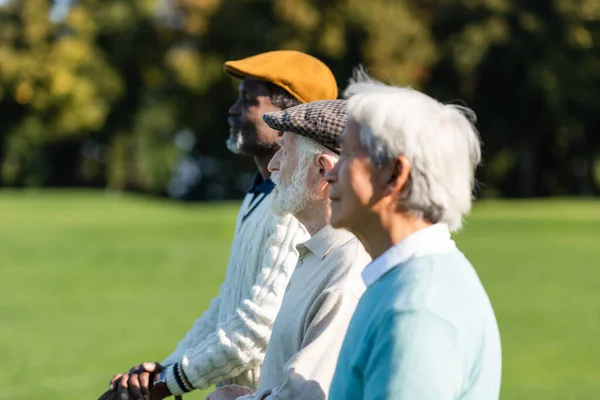 Seitenansicht eines älteren Mannes in der Nähe von interrassischen Freunden — Stockfoto