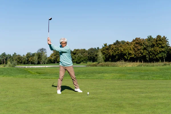 Повна довжина азіатського старшого чоловіка, який грає в гольф — стокове фото