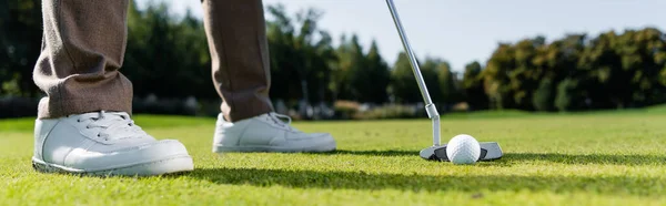 Cropped view of man in white sneakers playing golf on lawn, banner — Stock Photo