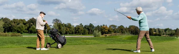 Senior asian man playing golf near friend with golf cart, banner — Stock Photo