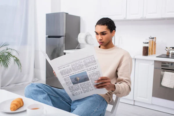 Afro-américain lecture de journal près du petit déjeuner sur la table — Photo de stock