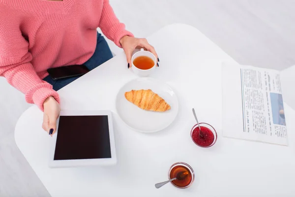 Cropped view of woman using digital tablet during breakfast — Stockfoto