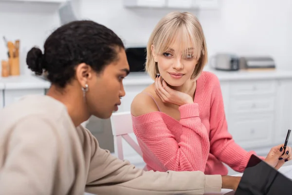 Blonde woman looking at african american boyfriend using laptop — Stock Photo