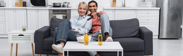 Happy interracial couple watching movie together, banner — стоковое фото