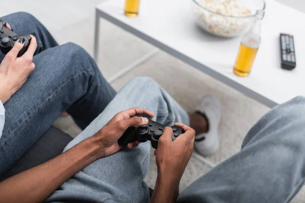 KYIV, UKRAINE - DECEMBER 6, 2021: top view of multiethnic couple playing video game — Stockfoto