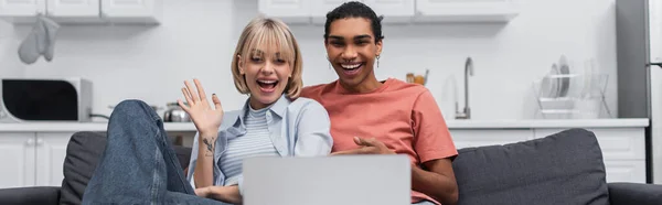 Homem americano africano alegre perto de namorada feliz acenando mão durante chamada de vídeo no laptop, banner — Fotografia de Stock