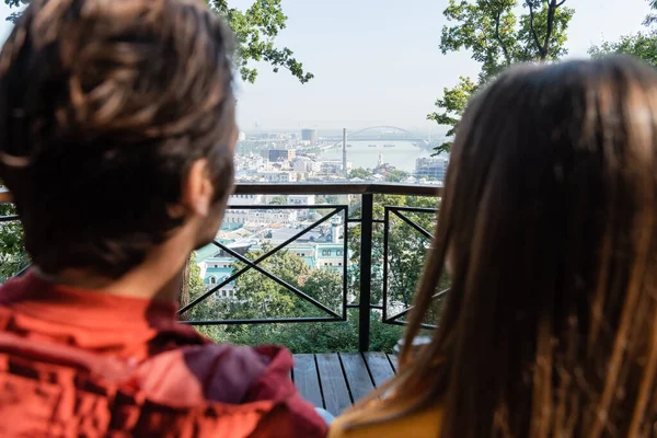 Vista posteriore di una coppia di turisti sfocati che guardano la città di giorno — Foto stock
