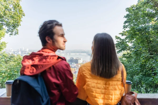 Blurred couple of tourists looking away near coffee to go outdoors — Stock Photo