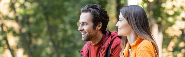 Smiling travelers looking away outdoors, banner — Stock Photo