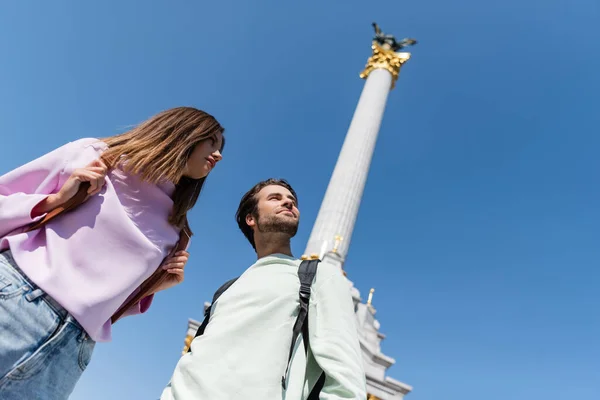 KYIV, UKRAINE - SEPTEMBER 1, 2021: Low angle view of travelers with backpacks looking away on Independence Square — Stock Photo