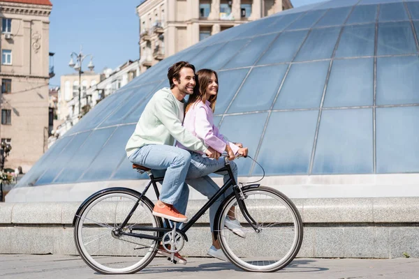 Positive couple of travelers cycling on urban street — Stock Photo