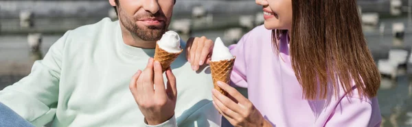 Cropped view of man holding ice cream near smiling girlfriend outdoors, banner — Stock Photo