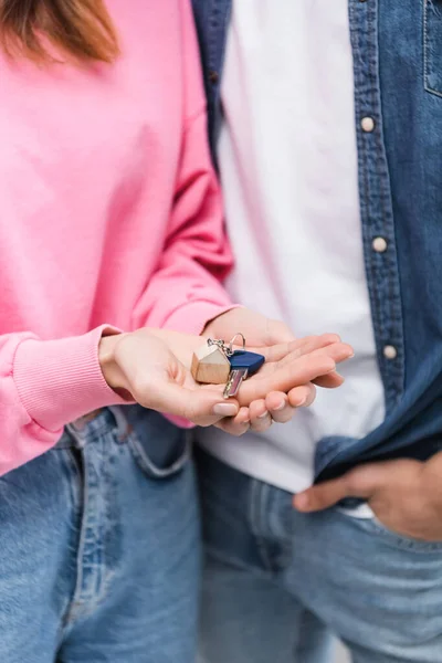 Ausgeschnittene Ansicht einer Frau mit Schlüssel in der Nähe ihres verschwommenen Freundes — Stockfoto