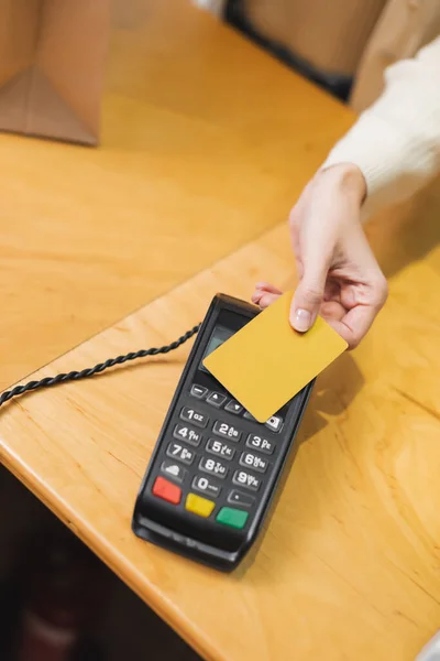 Обрізаний вид жінки, що платить кредитною карткою в другій руці — стокове фото