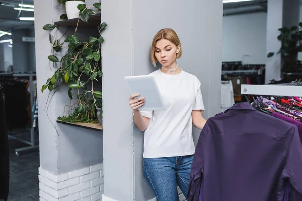 Blonder Einzelhändler nutzt digitales Tablet in Altkleidernähe — Stockfoto