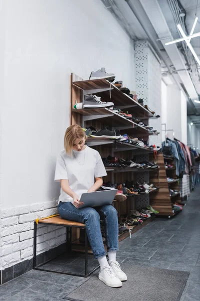 Blonde Verkäuferin benutzt Laptop aus zweiter Hand — Stockfoto