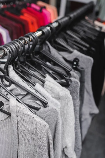 High angle view of jumpers on hangers in second hand - foto de stock