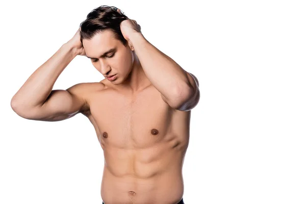 Uomo muscoloso senza maglietta toccare i capelli mentre posa isolato su bianco — Foto stock
