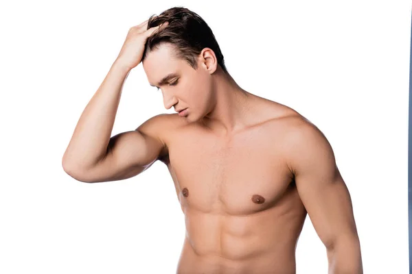 Hemdloser Mann mit muskulösem Oberkörper, der Haare auf weißem Hintergrund berührt — Stockfoto