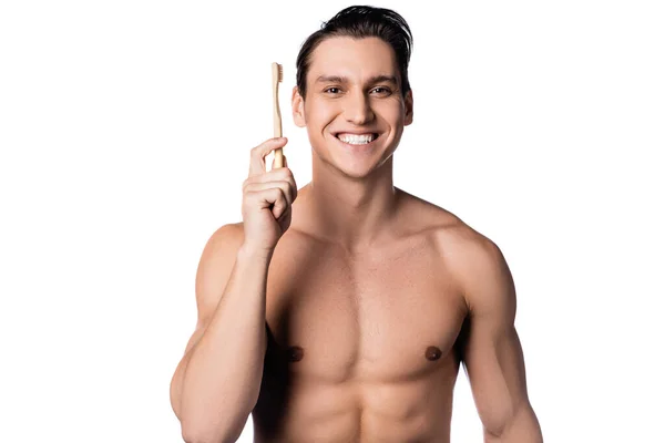 Lächelnder Mann mit muskulösem Oberkörper und Zahnbürste, der isoliert auf weiß in die Kamera blickt — Stockfoto