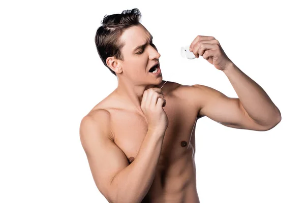 Мужчина без рубашки чистит зубы зубной нитью, изолированной на белом — стоковое фото
