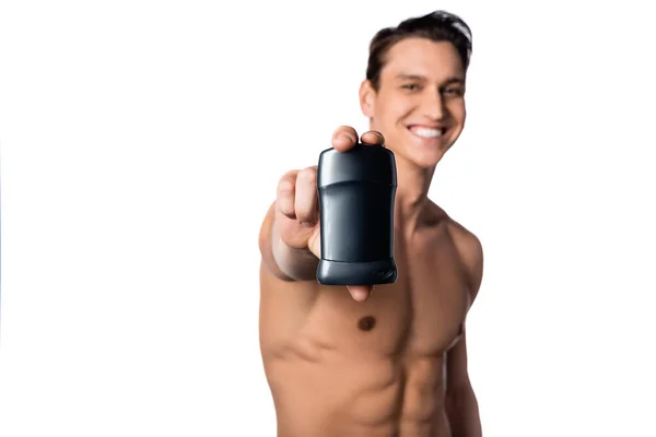 Щасливий без сорочки чоловік показує сухий дезодорант на розмитому фоні ізольований на білому — стокове фото