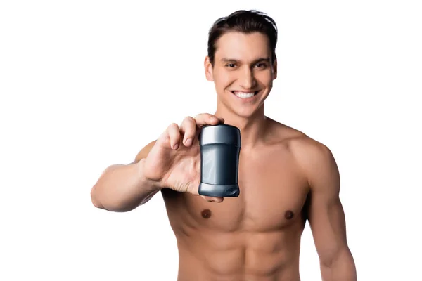 Sonriente hombre sin camisa sosteniendo desodorante seco aislado en blanco - foto de stock