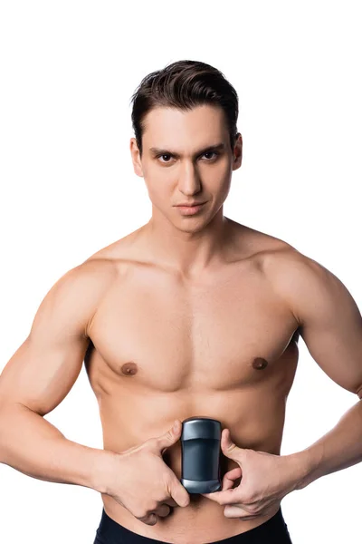 Shirtless man with muscular body holding dry deodorant and looking at camera isolated on white — Stock Photo