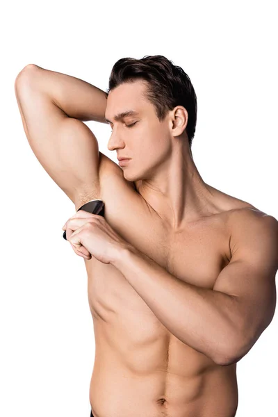 Homem sem camisa muscular aplicando desodorizante seco em axila isolada em branco — Fotografia de Stock