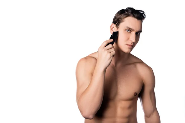 Hombre con el afeitado del cuerpo muscular con trimmer eléctrico aislado en blanco - foto de stock