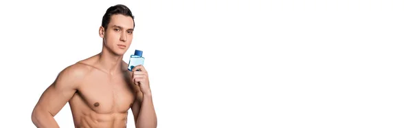 Shirtless man with strong body holding perfume and looking at camera isolated on white, banner — Stock Photo