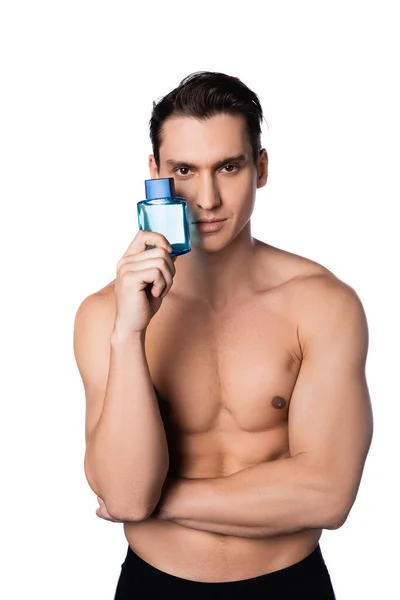 Hombre sin camisa con cuerpo perfecto celebración de perfume aislado en blanco - foto de stock