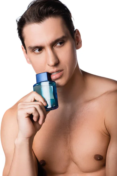 Uomo con petto nudo contenente fiala di profumo e distogliendo lo sguardo isolato su bianco — Foto stock