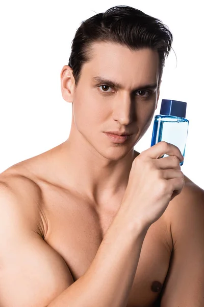 Hombre con hombros desnudos sosteniendo perfume mientras mira la cámara aislada en blanco - foto de stock