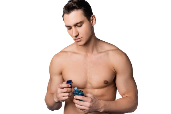 Brünette Mann mit muskulösen Körper öffnen Parfüm isoliert auf weiß — Stockfoto