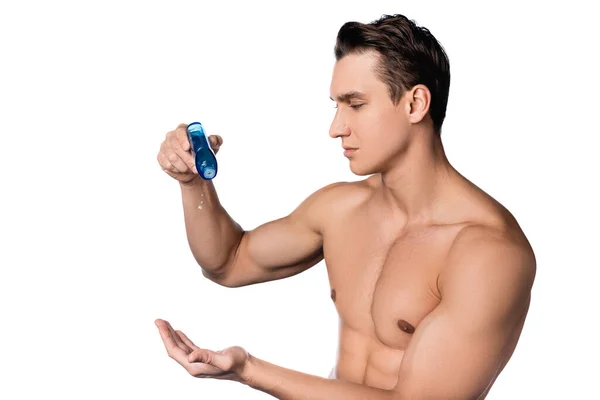 Hombre sin camisa con cuerpo perfecto aplicando loción después del afeitado en la mano aislado en blanco — Stock Photo