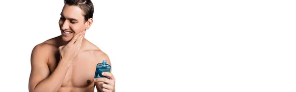 Happy man with bare chest applying after shave lotion isolated on white, banner — Stock Photo